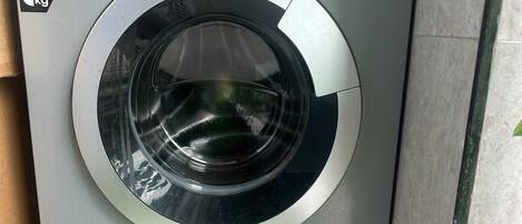 Una lavadora Hisense de carga frontal con panel de control, etiqueta que indica una capacidad de 6 kg y una nota sobre cerrar la puerta antes de iniciar el ciclo.