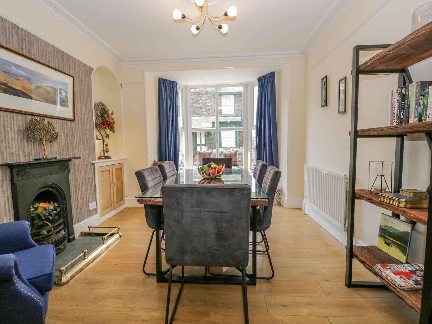 A dining area with a fireplace, a bookshelf, and a view of the outside.