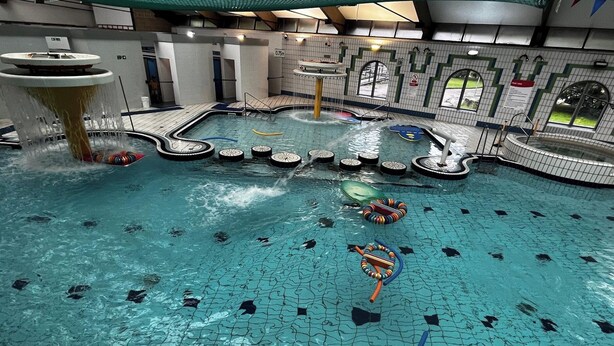 An indoor swimming pool with multiple lanes, a water slide, and a diving platform. - Tamar Cottages 35 (Gunnislake)