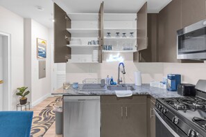 Une cuisine moderne équipée d’une cuisinière intégrée, d’un évier et de meubles hauts.