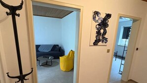 A hallway with a coat rack, a yellow bean bag chair, and a painting on the wall. - Forest View - near Rußweiher (Eschenbach in der Oberpfalz)