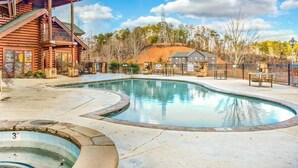 A log cabin-style building with a pool area, including a hot tub and a children's play area. - Suite at Dollywood Lane (Pigeon Forge)