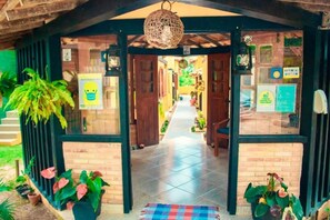 Entrada de hotel con un camino empedrado que conduce a una puerta de madera.