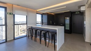 Une cuisine moderne avec un coin bar, de grandes fenêtres et une vue sur la ville.