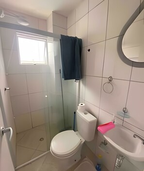 A small bathroom with a toilet, sink, and shower. - House with pool in Maresias - SP (1) (Sao Sebastiao)