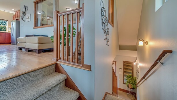 A staircase with a wooden handrail and a small potted plant at the bottom. - Charming 1-bedroom house with WiFi, AC , laundry in lovely Snohomish (Snohomish)