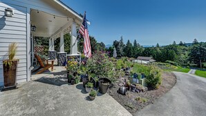 A house with a covered porch, an American flag, and a variety of potted plants. - Charming 1-bedroom house with WiFi, AC , laundry in lovely Snohomish (Snohomish)