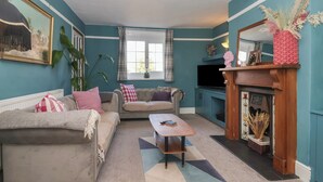 A living room with two sofas, a coffee table, a fireplace, and a television. - Rose Cottage (Cottingham)