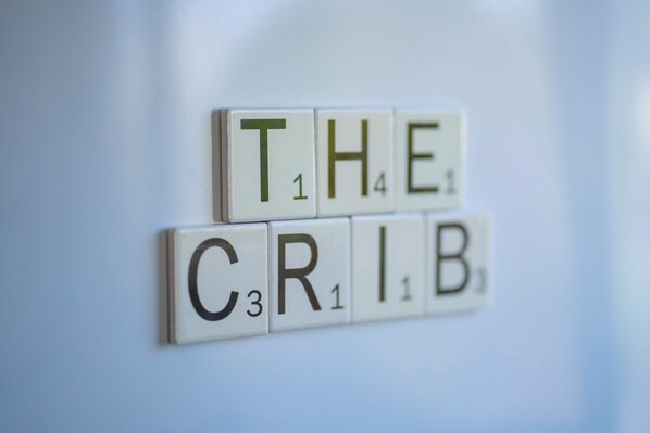 Scrabble tiles spelling "THE CRIB" on a white surface.