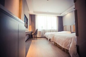 A hotel room with a desk, two beds, a chair, and a large window with curtains. - Yong Xu Hotel (Antu)