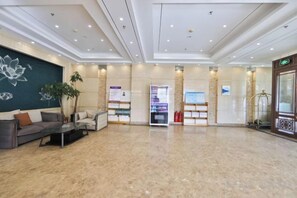 A spacious lobby with a reception desk, seating area, and a display of informational brochures. - Yong Xu Hotel (Antu)