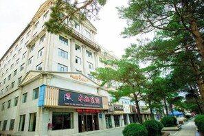 A multi-story building with a commercial ground floor, including a restaurant with a prominent sign. - Yong Xu Hotel (Antu)