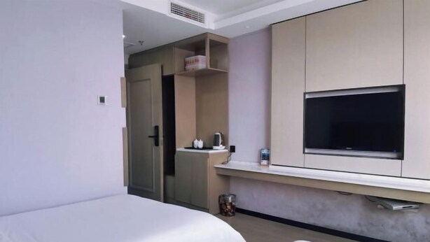 A hotel room with two beds, a TV mounted on the wall, and a small kitchenette area. - Yong Xu Hotel (Antu)