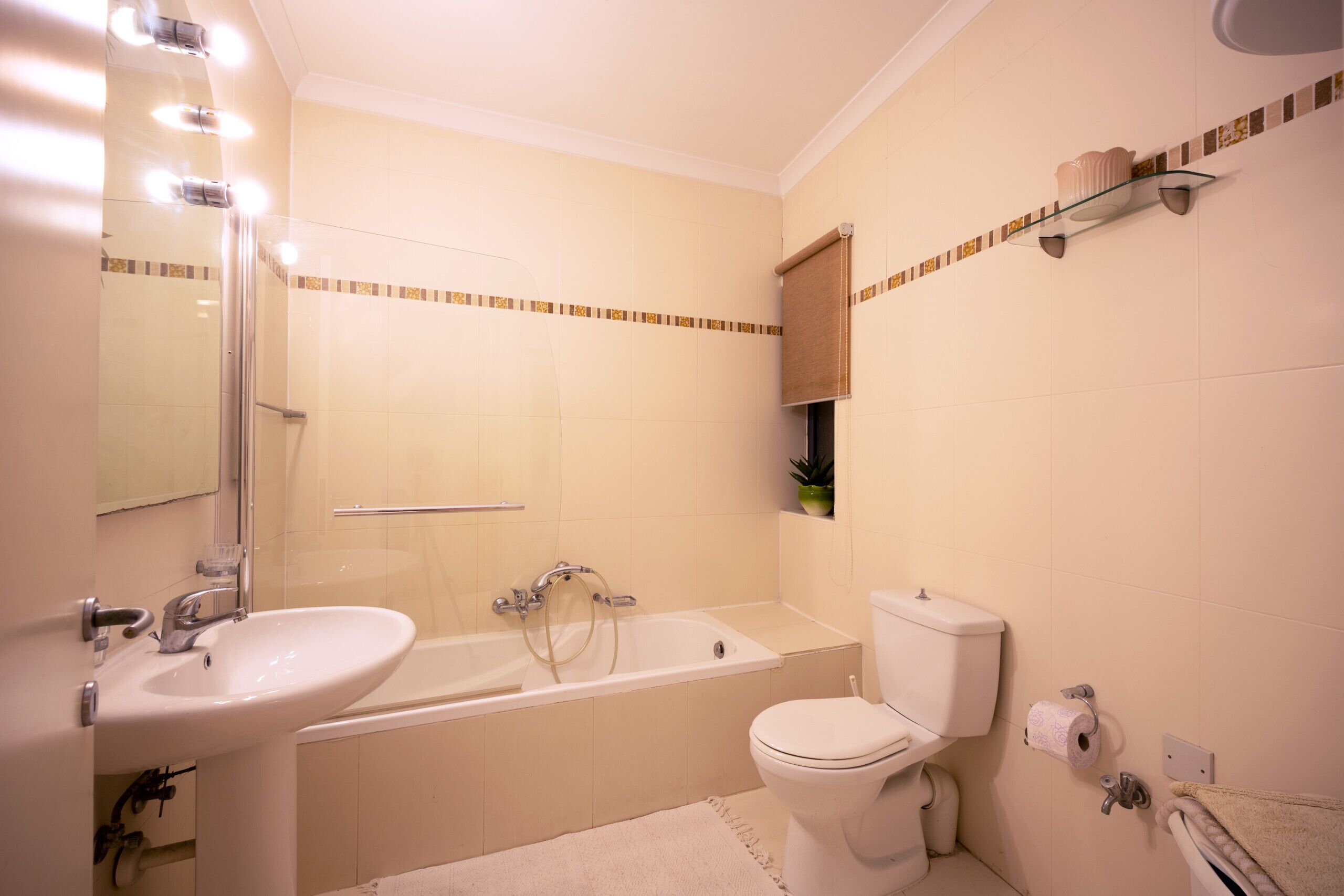 A bathroom with a sink, bathtub, toilet, and a mirror.