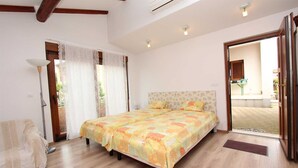 A bedroom with a bed, a chair, and a window with curtains. - ROVINJ HOME Studio with Terrace (Rovinj)