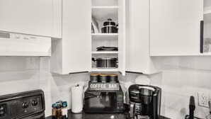 A kitchen with a coffee bar, a Keurig coffee maker, and a microwave.