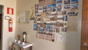 A wall with a bulletin board displaying various photographs and information about local attractions. - Comfort Suite 102 - Acayaca Inn (Centro Diamantina)