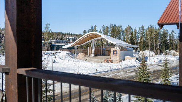 Un edificio moderno con techo curvo, rodeado de nieve y árboles.