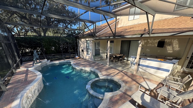 A backyard with a swimming pool, hot tub, and outdoor seating area. - Southern Comfort on Hampton Lakes - The Ultimate Luxury Retreat! (Davenport)