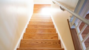 A wooden staircase with a white handrail, leading upwards. - Fabulous 3bdrm Home w/parking! (Highland Falls)