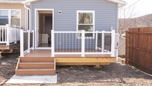 A house with a wooden deck, a white railing, and a front door. - Fabulous 3bdrm Home w/parking! (Highland Falls)