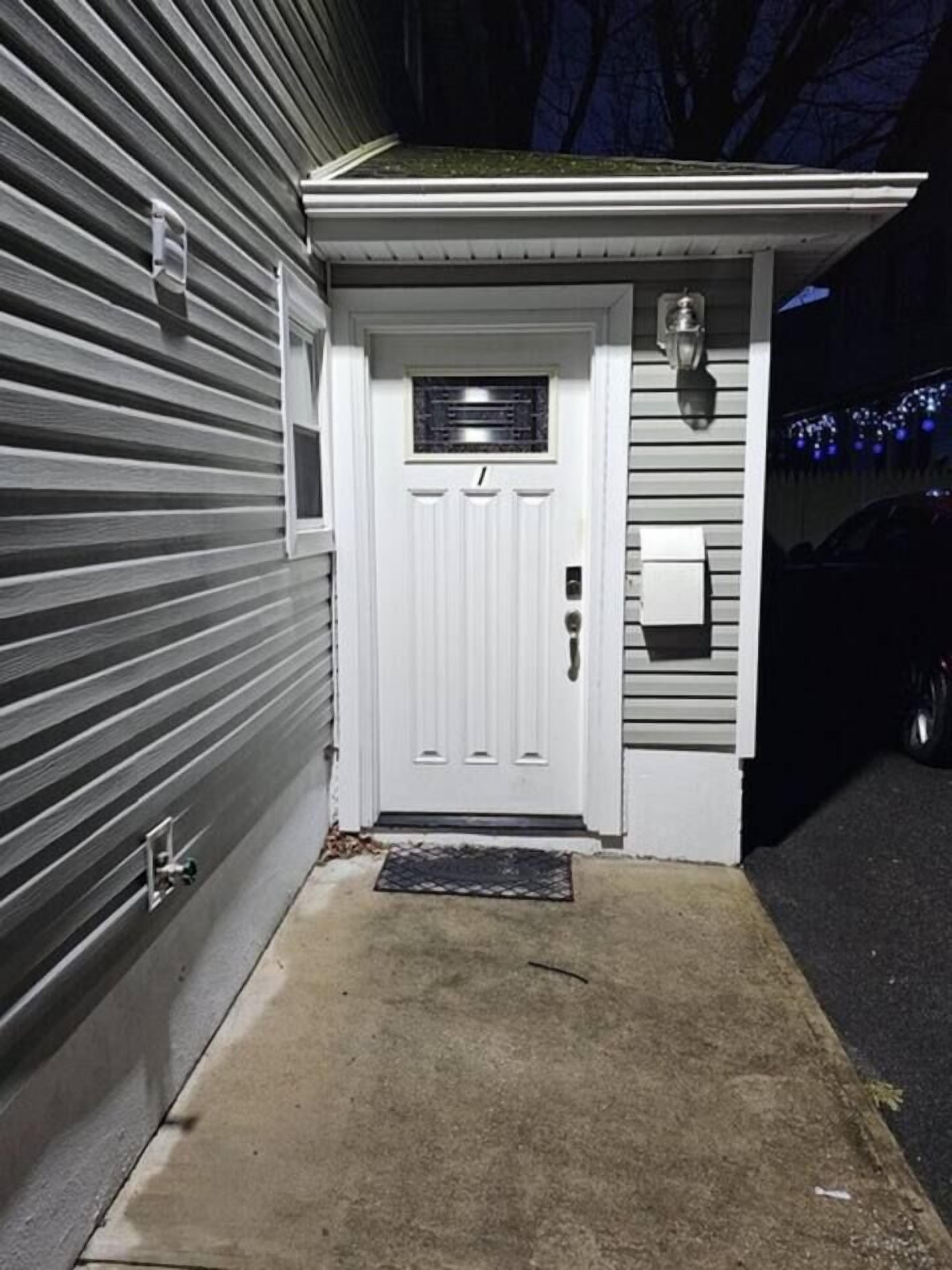 Een witte garage deur met een klein raam en een brievenbus.