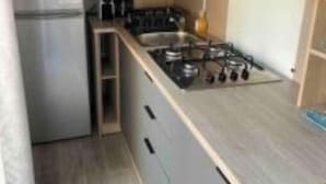 A compact kitchen with a refrigerator, stove, and microwave.