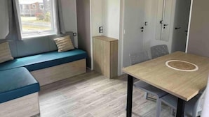 A compact room with a wooden bench, a table, and a wardrobe.