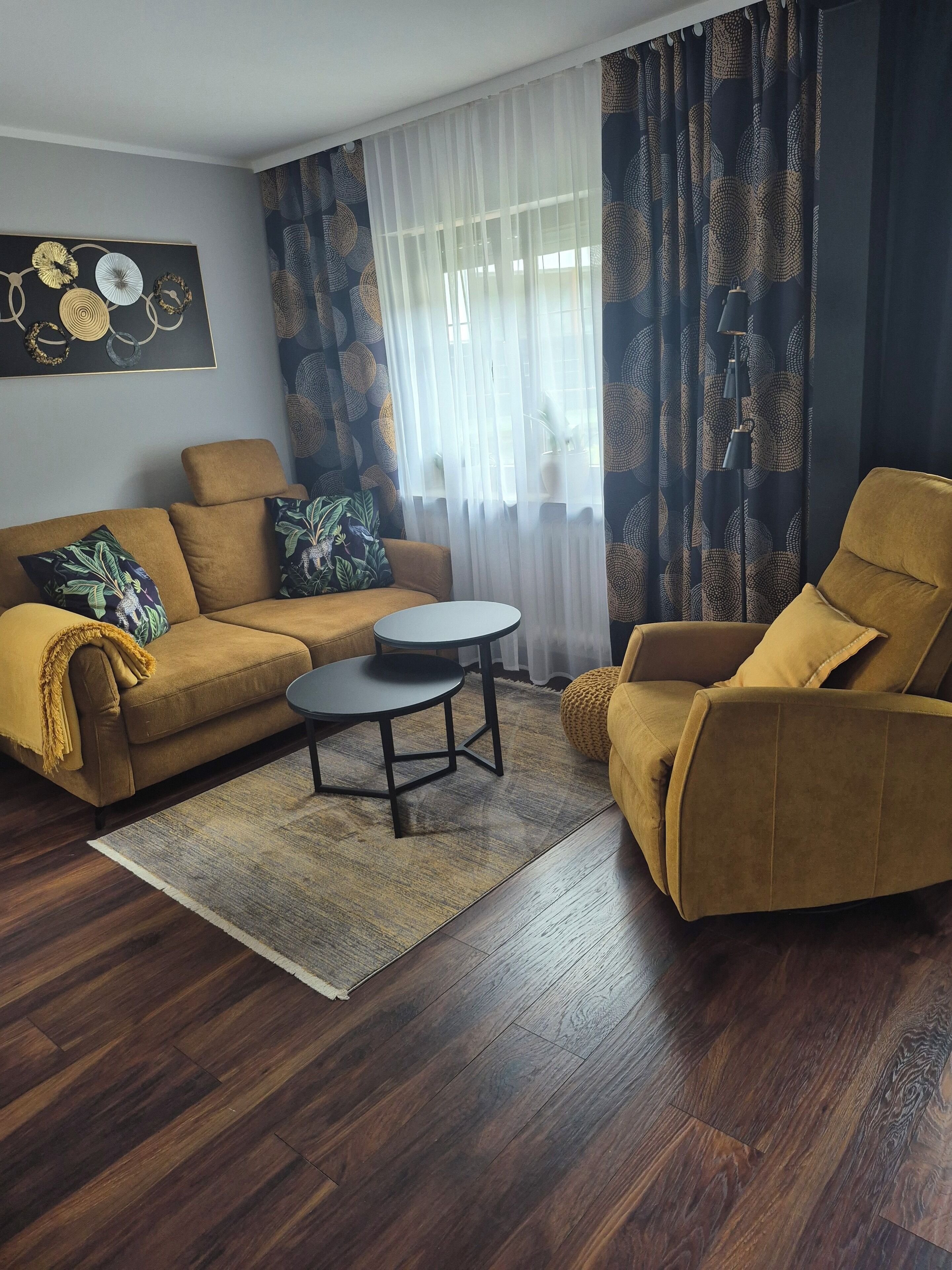 A living room with a sofa, armchair, and round coffee table.