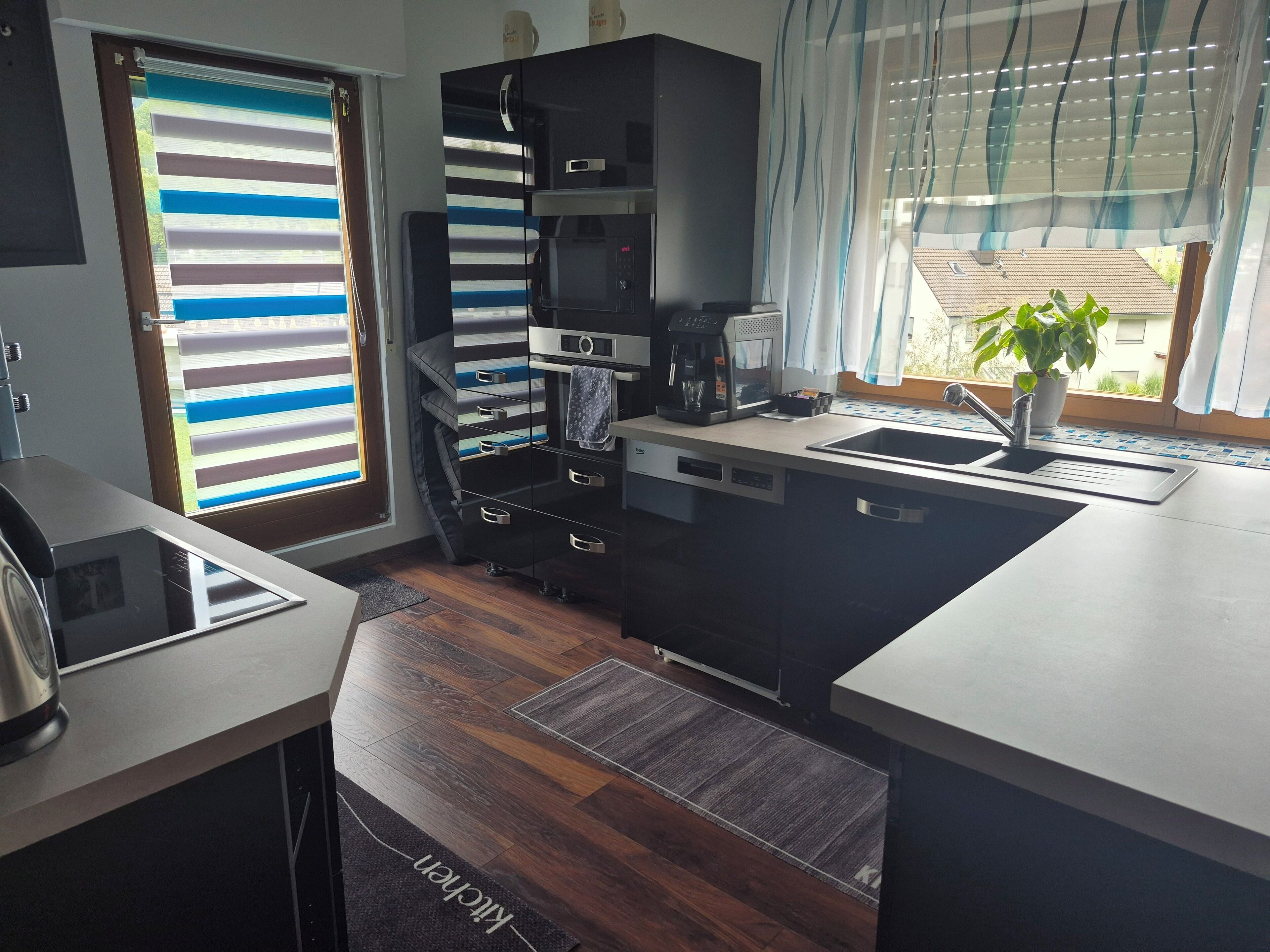 Cocina compacta con lavavajillas integrado, cafetera y lavabo.