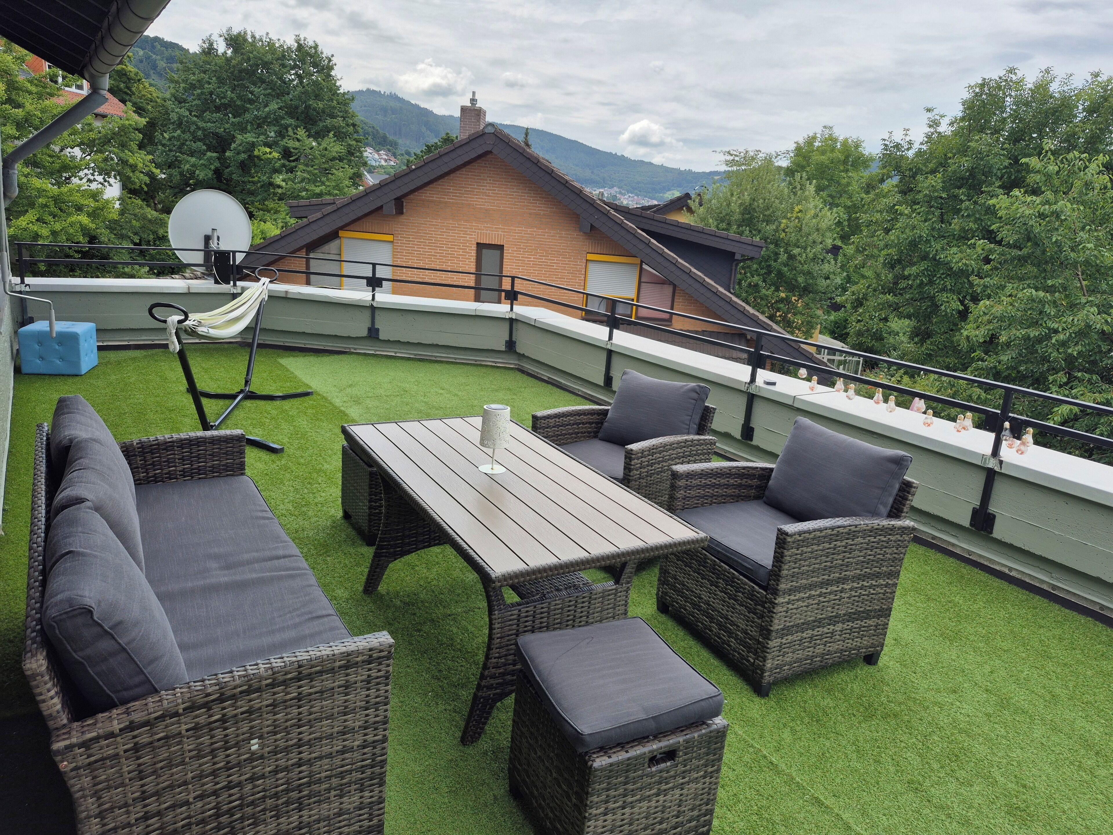 Eine Terrassengaststätte mit Korbmöbeln, einem Tisch und einer Hängematte.