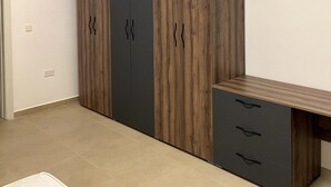 Ein Schlafzimmer mit Bett, Schrank und Schreibtisch.