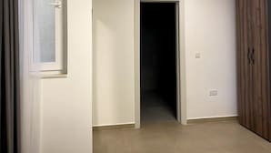 Ein Schlafzimmer mit Bett, Tür und Kleiderschrank.