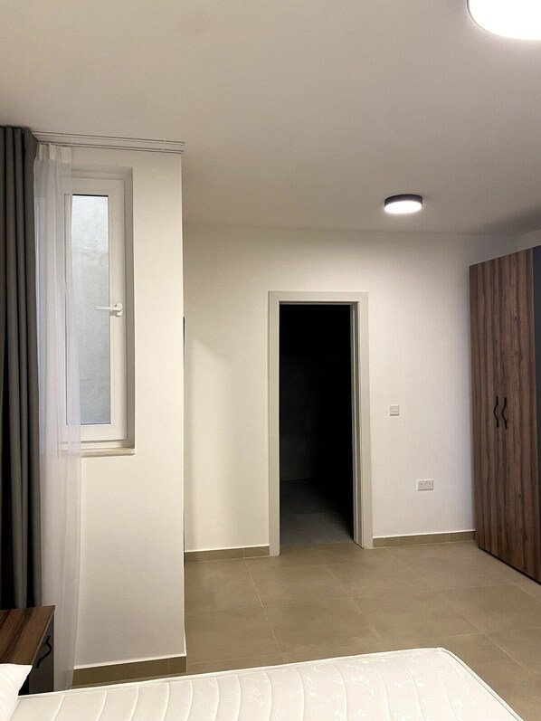 Een slaapkamer met een bed, een deur en een kledingkast.