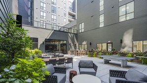 An outdoor patio area with seating arrangements, a ping pong table, and a barbecue grill. - King Bed Comfort | Free Parking | UPMC, Pitt & CMU (Pittsburgh)