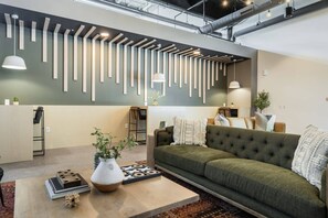 Ein modernes Wohnzimmer mit einem Ecksofa, einem Couchtisch und einer Wandleuchte.