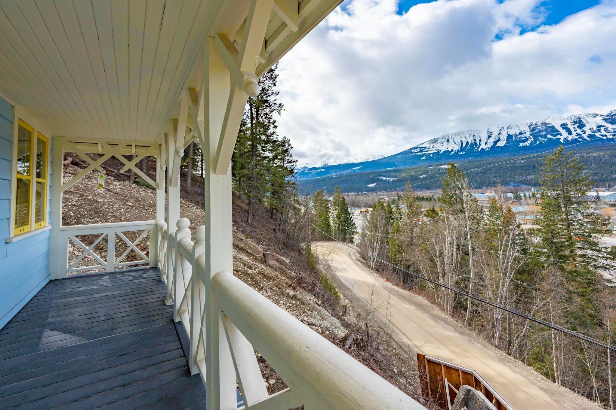 A wooden deck with a railing overlooking a mountainous landscape.