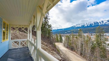 A wooden deck with a railing overlooking a mountainous landscape.