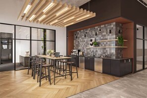 A modern kitchen with a herringbone wood floor, a central island with stools, a built-in oven, and a backsplash with gray tiles. - OTR | King Bed l Free Parking | Gym | Top Floor (Cincinnati)