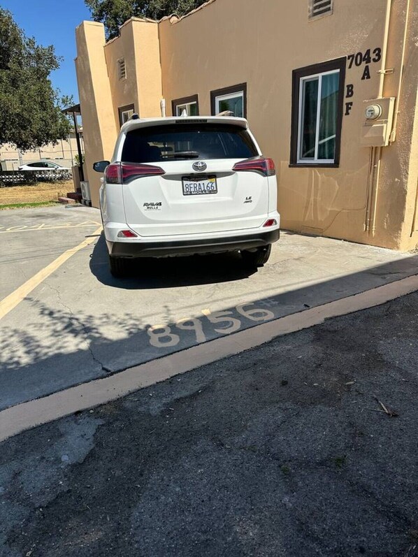 A white SUV parked in a parking lot with a building in the background.