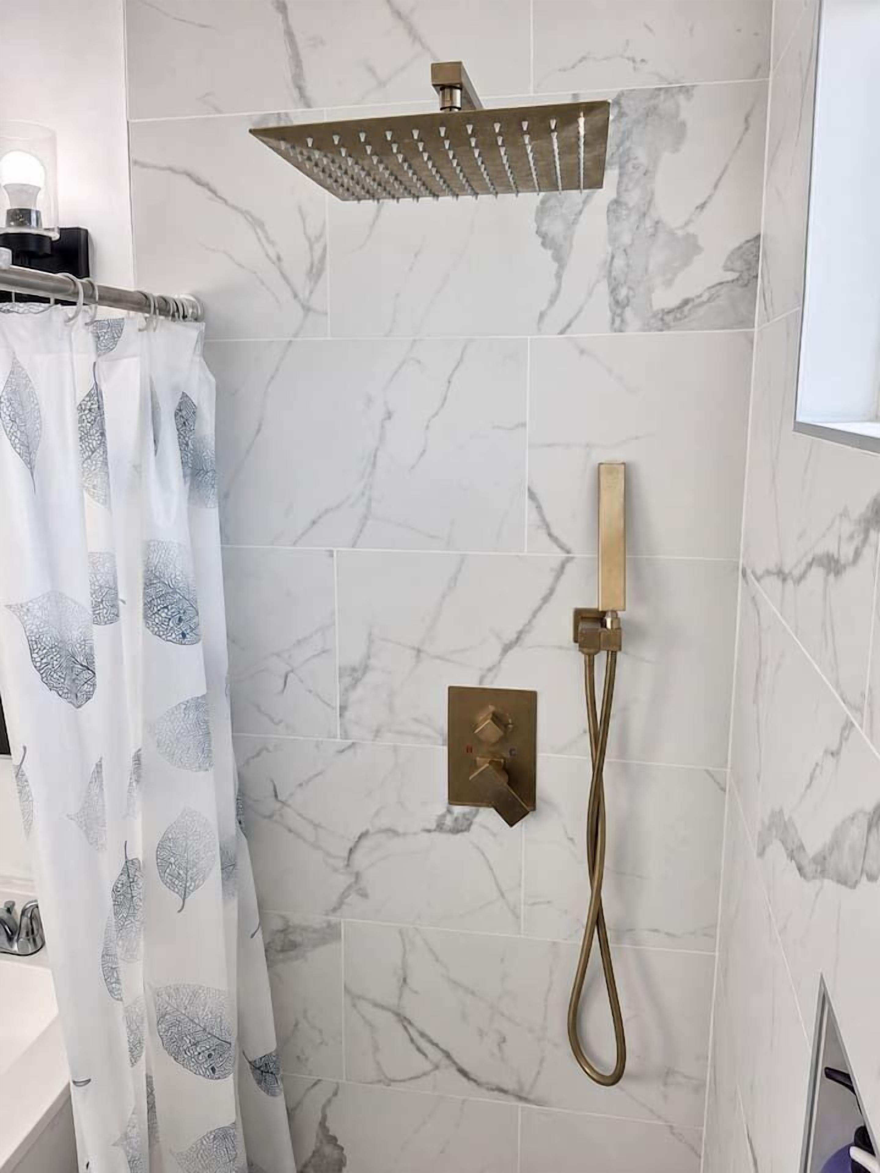 A bathroom with a shower, a toilet, and a sink.