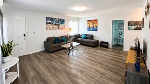 A living room with two sofas, a coffee table, and a TV stand. - Central San Gabriel - Sleeps 4, Pet Friendly Unit (San Gabriel)