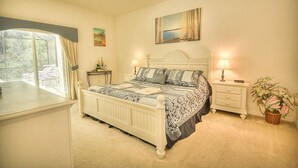 A bedroom with a bed, nightstands, a ceiling fan, a window, and a painting on the wall. - Charming 4-bedroom Villa With Pool & Spa, Only 15 Minutes From Disney! (Kissimmee)