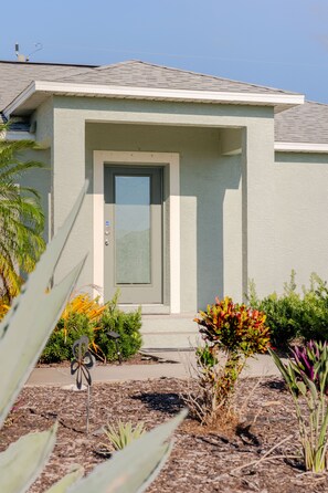 A single-story house with a flat roof, a front door, and a small porch area.