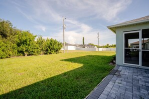 Ein Wohnhaus mit gepflegtem Rasen, ein freistehendes Haus inklusive Garage und einem wolkenlosen Himmel.