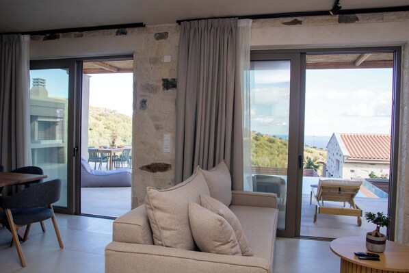 Deluxe villa, uitzicht op zee | Woonruimte | Flatscreentelevisie en een open haard