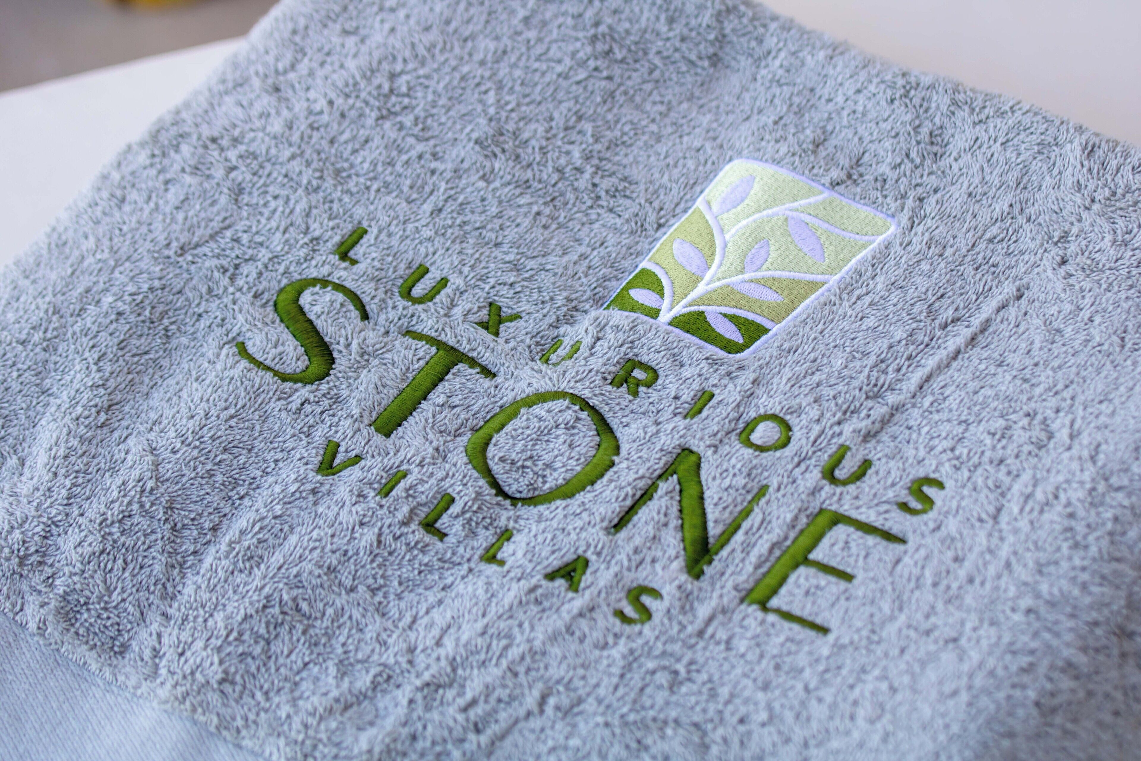 A towel with embroidered text "LUXURIOUS STONE VILLAS".