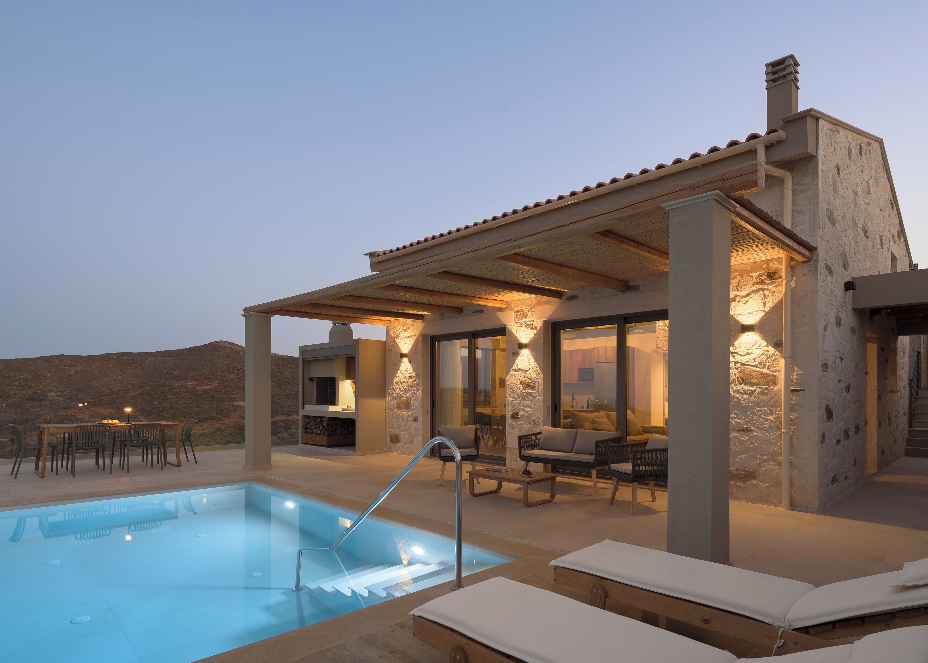 A poolside area with a pool, lounge chairs, and a covered seating area.