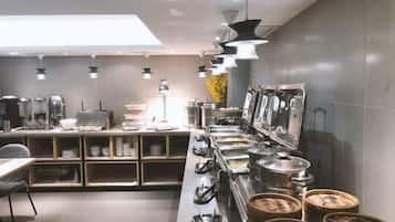 Una cocina moderna con electrodomésticos de acero inoxidable, una encimera amplia e iluminación en el techo.
