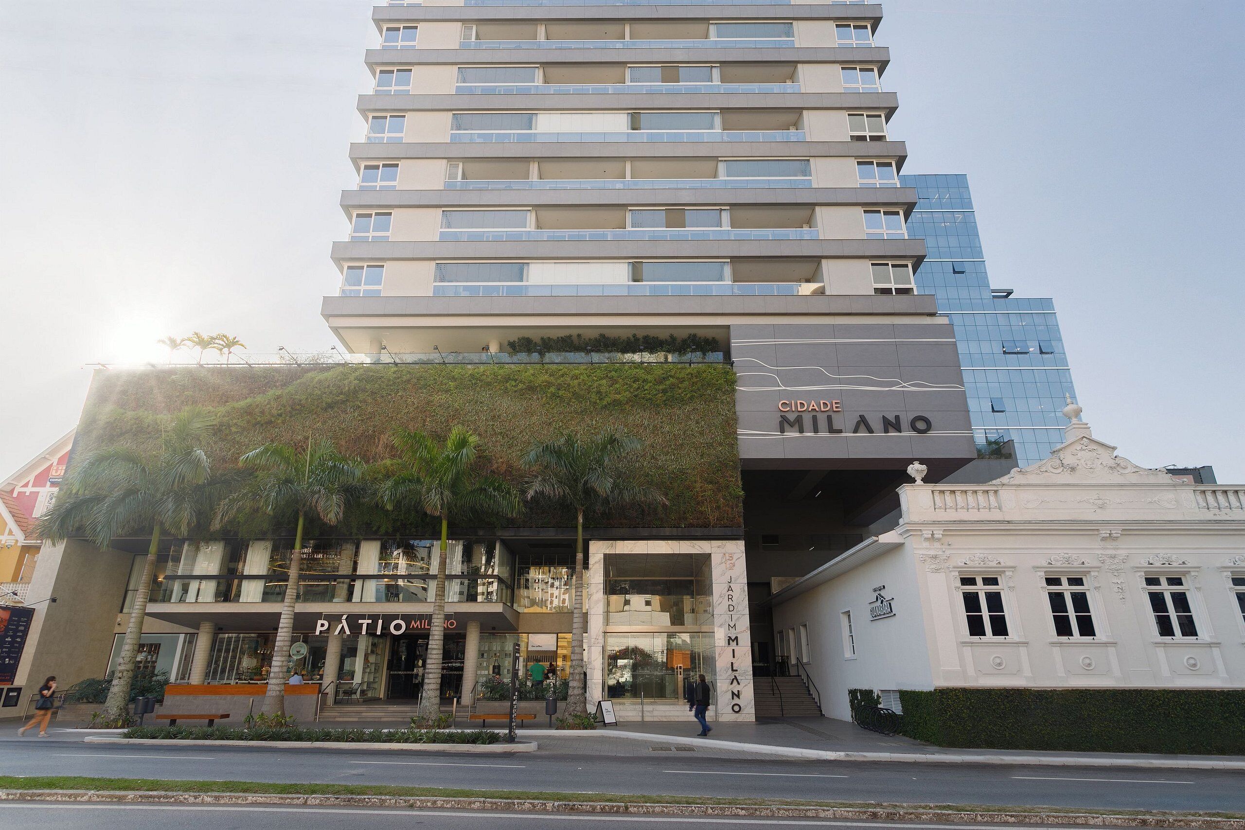 Un edificio de varios pisos con un diseño moderno, que combina fachadas de vidrio y concreto.